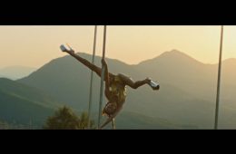 Lucia pole dancing outdoors with a dramatic mountain backdrop