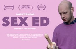 Sex Ed - a man looks at a dildo in a puzzled and stressed way